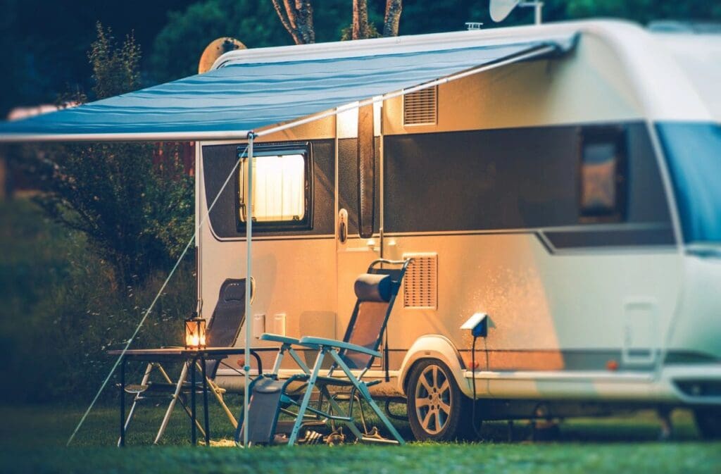 Cozy camper van setup with chairs and a table under warm lights.