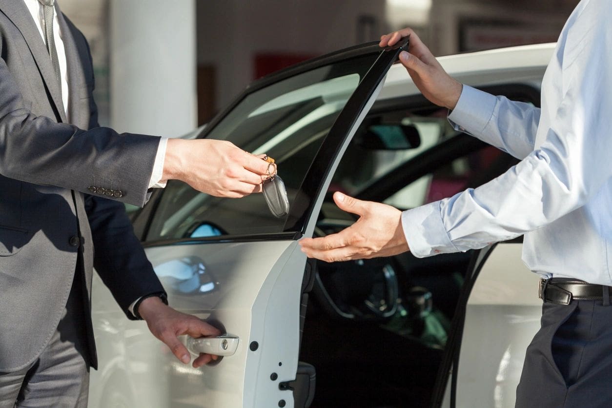 A person opening a car door for another person.