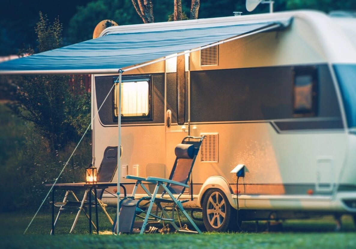 Cozy camper van setup with chairs and a table under warm lights.