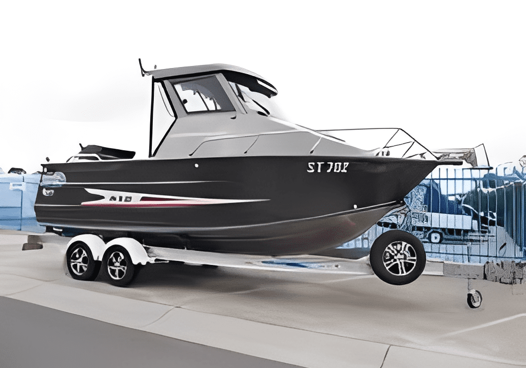 A sleek black and silver motorboat on a trailer indoors.